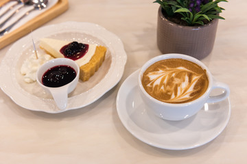 Latte art coffee cup with pie cake on marble table