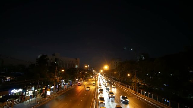 4k of traffic on Ngamwongwan Road with sunset at Kasetsart University in bangkok, Thailand