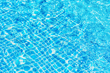 surface of ripple water in swimming pool with sun reflection