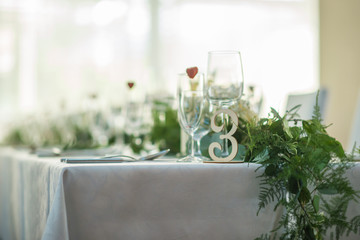 wedding table with exclusive floral arrangement prepared for reception, wedding or event centerpiece in greenery style