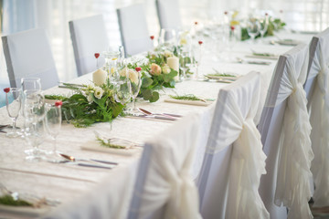 wedding table with exclusive floral arrangement prepared for reception, wedding or event centerpiece in greenery style