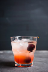 Old fashioned cocktail with cherry. Selective focus.