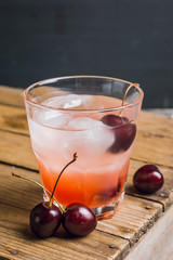 Old fashioned cocktail with cherry. Selective focus.