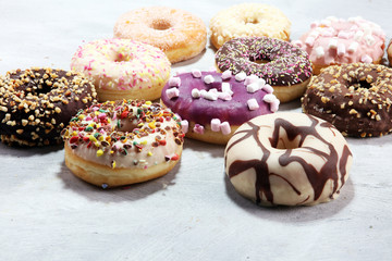 assorted donuts with chocolate frosted, pink glazed and sprinkles donuts