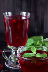 Berry kissel in a glass cup and in a mug against the dark background