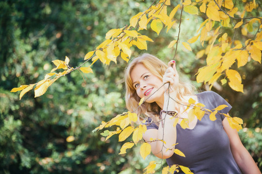 Young Blond Hair Woman In Autumn City Park In Warm Fall Season Sunny Day