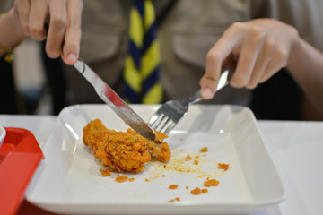 Knife cutting fried chicken on the plate