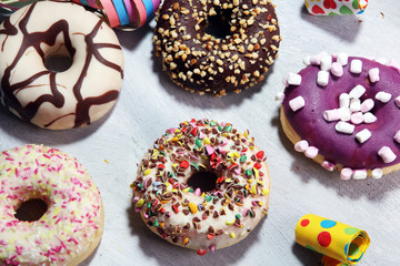 assorted donuts with chocolate frosted, pink glazed and sprinkles donuts