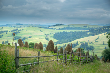 Fototapeta na wymiar Stack of hay on a mountain meadow on a hillside.