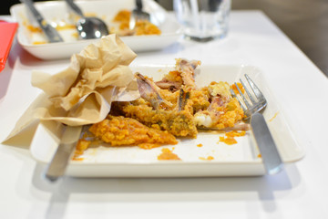 Remains of fried chicken on the plate
