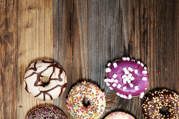 assorted donuts with chocolate frosted, pink glazed and sprinkles donuts