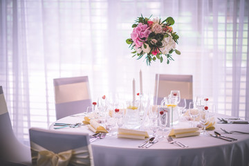 Wedding table with exclusive floral arrangement prepared for reception, wedding or event centerpiece in romantic pink style