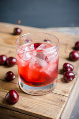 Old fashioned cocktail with cherry. Selective focus.