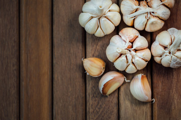 Garlic and cloves upper right corner on wooden background