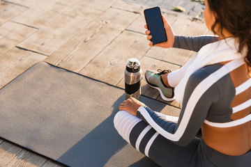 Fitness woman outdoors using mobile phone.