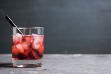 Old fashioned cocktail with cherry. Selective focus.