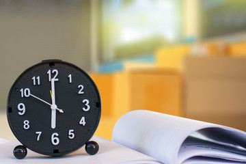 Holding clock on industry blurred background The time 12:00 am or pm and noon or midnight for made...