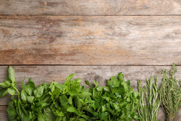 Different fresh herbs on wooden table, top view
