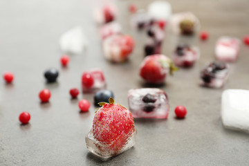 Different frozen berries on gray table