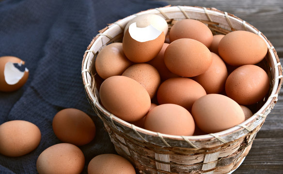 Healthy and benefits of chicken egg..Many chicken eggs in basket on wooden background.