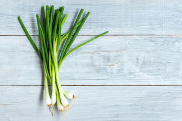 fresh spring onion on white wooden background.