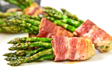 Bacon Wrapped Asparagus Bundles on white dish..spring vegetable season with BBQ menu.