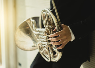 Young man playing french horn classical music - obrazy, fototapety, plakaty