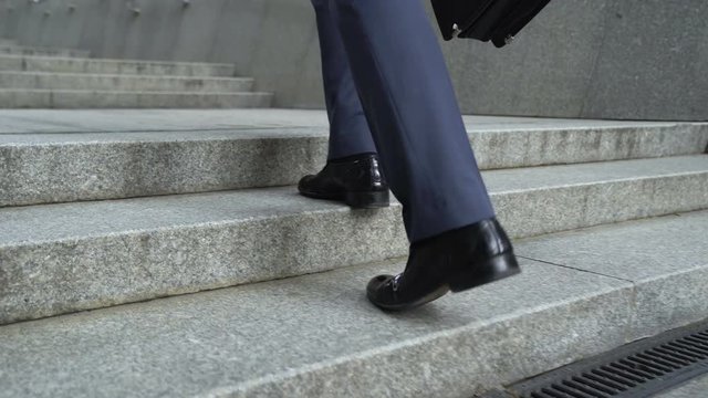 Closeup of businessman climbing stairs, concept of success in career, promotion