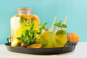 Mojito cocktail in mason jar with mint on blue. Copy space for text.