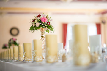Wedding table with exclusive floral arrangement prepared for reception, wedding or event centerpiece in romantic gold style
