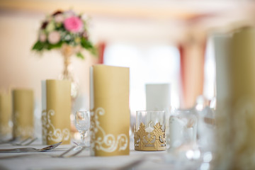 Wedding table with exclusive floral arrangement prepared for reception, wedding or event centerpiece in romantic gold style