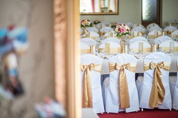 Wedding table with exclusive floral arrangement prepared for reception, wedding or event centerpiece in romantic gold style