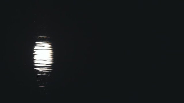 Moon path on the water at night. Reflection of the moonlight on the water. Low Key