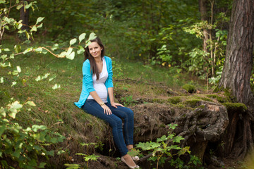 Beautiful portrait of pregnant woman in the forest