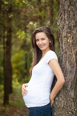 Beautiful pregnant woman in the forest