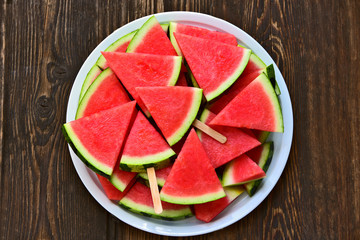 Colorful and a lot of watermelon slice with ice cream stick in big white dish on wooden background..Watermelon As The Best Food For Weight Loss In Summer Season.