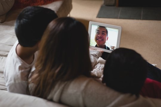 Mother and kids having video call on laptop in living room