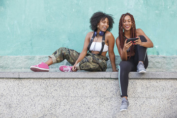 group of afro american women using technology on the street