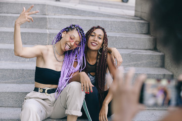 young women with colorful braids hugging and having fun