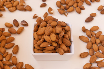 Raw almonds on a white plate.