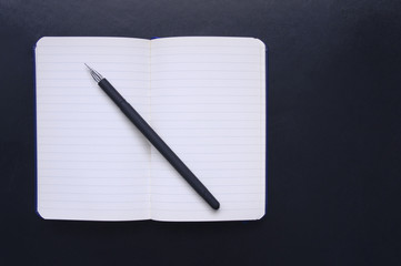 Notepad with line and pen on a black background. Notebook and pen. A man's notepad. Back to school, the classic strict style. Business concept, Paper for notes, Office chancery