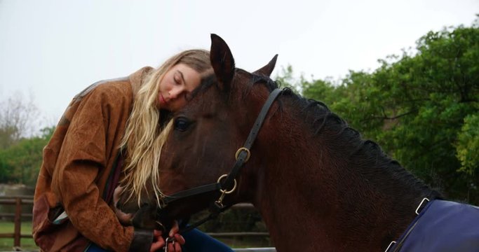 Woman hugging horse on wooden fence at ranch 4k