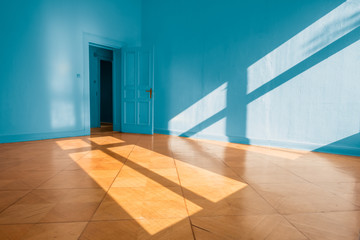bright empty apartment room with blue walls and wooden floor