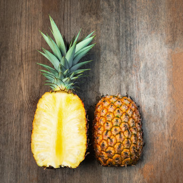 Pineapple fruit cut two halves top wooden background negative space. Square Composition. Juicy organically grown ripe and sweet