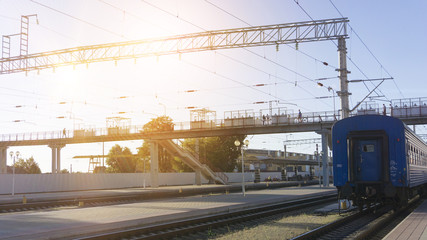 Power lines on the railway. Blue sky, sunlight. Railway