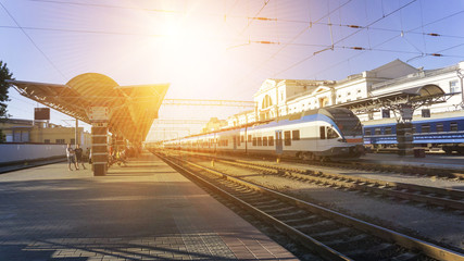 Fototapeta premium Power lines on the railway. Blue sky, sunlight. Railway