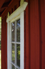 White window in a red wooden house