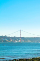 Ponte 25 de Abril, suspension Bridge in Lisbon, Portugal. Connects the cities of Lisbon and Almada crossing the Tagus River. Evening photo.