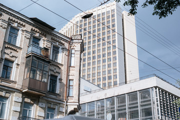 Fototapeta premium high-rise multi-storey apartment building with trees infront blue sky and clouds