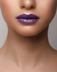 Obraz premium Close-up of woman's lips with bright fashion pink glossy makeup. Macro magenta lipgloss make-up. Sexy pink lip makeup. Highly saturated color. Lipstick